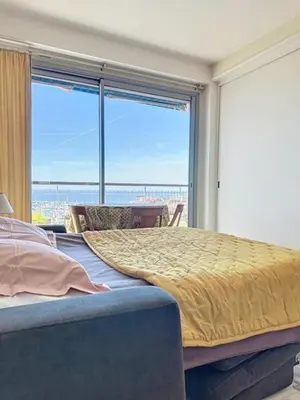 a bedroom with a bed and a large window at AGENCIA dernier étage vue mer panoramique in Cannes