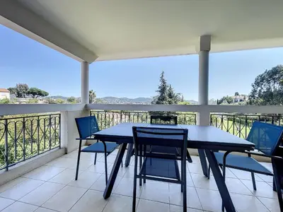 a porch with a table and chairs on a balcony at Cannes - 2 pièces résidence avec parc et piscine in Cannes