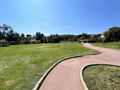 a winding path in a park with a grass field at Cannes - 2 pièces résidence avec parc et piscine in Cannes