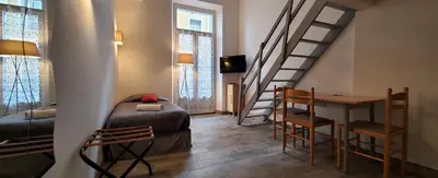 a room with a staircase and a bed and a table at STUDIOS PARISIENS in Cannes