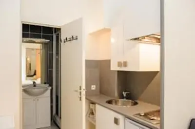 a kitchen with white cabinets and a sink at STUDIOS PARISIENS in Cannes