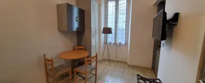a small room with a small table and a television at STUDIOS PARISIENS in Cannes