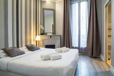 a bedroom with two large beds and a fireplace at Superbe 120m2 au Suquet - Property With Style in Cannes