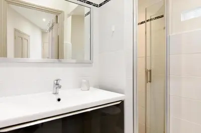 a white bathroom with a sink and a shower at Bright and elegant renovated two rooms - Near Suquet in Cannes