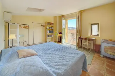 a bedroom with a large bed and a window at Townhouse in the heart of the suquet - 4 bedrooms in Cannes
