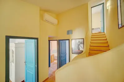 a staircase in a room with yellow walls and blue doors at Townhouse in the heart of the suquet - 4 bedrooms in Cannes