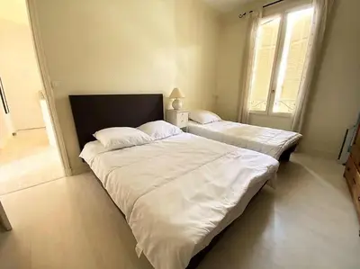 a bedroom with two beds with white sheets and a window at C043-Agréable 3 Pièces proche Croisette et plages in Cannes