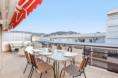 a balcony with a table and chairs on a roof at XXL 2 beds with XXL terrace next to Martinez Hotel in Cannes