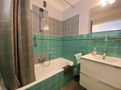 a green tiled bathroom with a tub and a sink at C048 Studio Spacieux proche Plages et Palais in Cannes