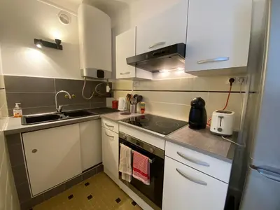 a small kitchen with white cabinets and a sink at C048 Studio Spacieux proche Plages et Palais in Cannes