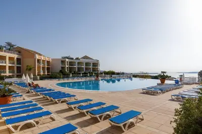 a swimming pool with blue lounge chairs and a resort at Chagall 3 étoiles in Cannes