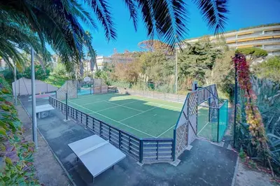 a tennis court with a net and a tennis at Chagall 3 étoiles in Cannes