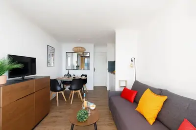 a living room with a gray couch and a table at Chagall 3 étoiles in Cannes
