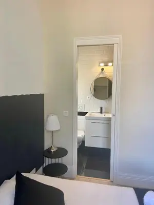 a bedroom with a bed and a bathroom with a sink at The Loft - Superb 2 bedrooms on top floor with terrace - 10min to Palais & Beach! in Cannes