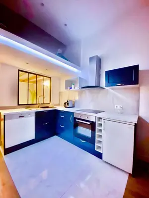 a kitchen with blue and white cabinets and a sink at Le somptueux Le Gallia in Cannes