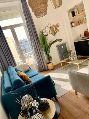a living room with a blue couch and a window at Le somptueux Le Gallia in Cannes