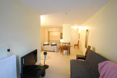 a living room with a couch and a room with a bed at antares57 in Cannes