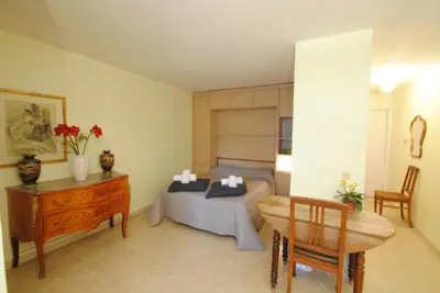 a bedroom with a bed and a desk and a table at antares57 in Cannes