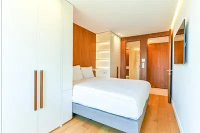 a bedroom with a white bed and wooden cabinets at Luxurious apartment with terrace 6P - 3BR - Grand in Cannes