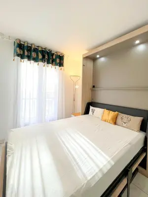 a bedroom with a large white bed in front of a window at Palazzio 3, quartier vieux port avec parking, by Welcome to Cannes in Cannes