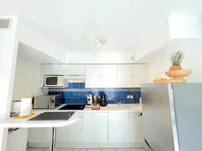 a kitchen with white cabinets and a counter top at Palazzio 3, quartier vieux port avec parking, by Welcome to Cannes in Cannes