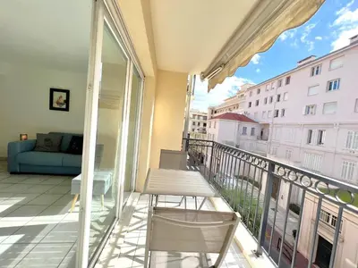 a balcony with a couch and a view of a building at Palazzio 3, quartier vieux port avec parking, by Welcome to Cannes in Cannes
