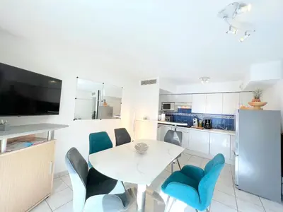 a kitchen with a white table and blue chairs at Palazzio 3, quartier vieux port avec parking, by Welcome to Cannes in Cannes