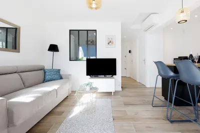 a living room with a couch and a tv at Palladium 148 YourHostHelper in Cannes
