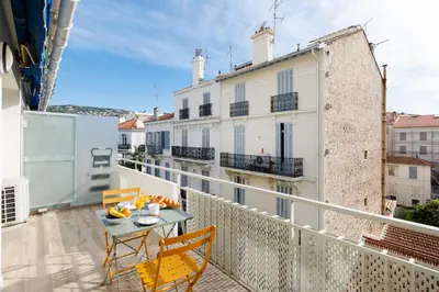 a balcony with a table and chairs on a building at Palladium 148 YourHostHelper in Cannes