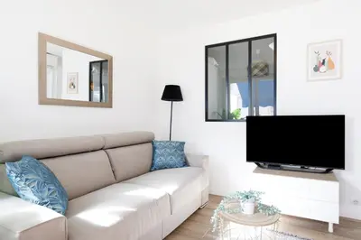 a living room with a couch and a flat screen tv at Palladium 148 YourHostHelper in Cannes