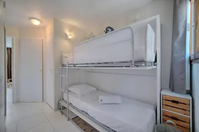 a room with two bunk beds in a room at IMMOGROOM - Renovated - Sea view - Pool - Patio - Wifi - AC - Parking in Cannes