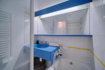 a bathroom with a blue sink and a mirror at IMMOGROOM - Renovated - Sea view - Pool - Patio - Wifi - AC - Parking in Cannes