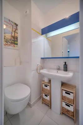 a white bathroom with a toilet and a sink at IMMOGROOM - Renovated - Sea view - Pool - Patio - Wifi - AC - Parking in Cannes