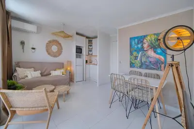 a living room with a couch and a table and chairs at IMMOGROOM - Renovated - Sea view - Pool - Patio - Wifi - AC - Parking in Cannes