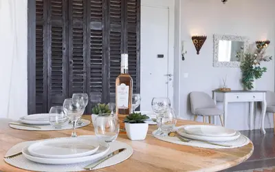 a wooden table with a bottle of wine and glasses at Bel Appartement 5* Vue Mer Et Suquet - Centre Cannes in Cannes