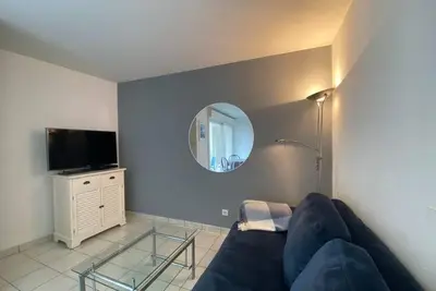 a living room with a blue couch and a mirror at C057-Appart fonctionnel - 4 Pers - Cannes Suquet-Clemenceau in Cannes