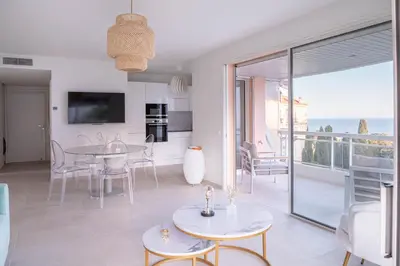 a swimming pool with chairs and the ocean in the background at Dream Apartment by Halldis in Cannes