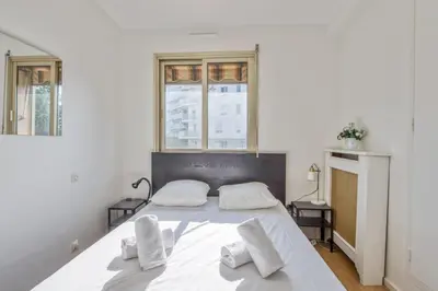 a white bedroom with a large white bed with two pillows at Appartement Berthelotine - Welkeys in Cannes