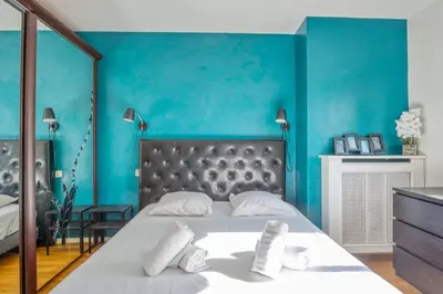 a bedroom with blue walls and a bed with white pillows at Appartement Berthelotine - Welkeys in Cannes