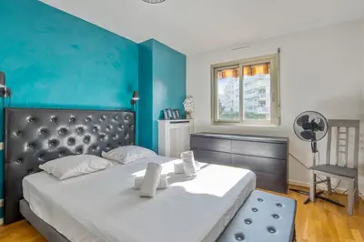 a bedroom with a large bed with a blue wall at Appartement Berthelotine - Welkeys in Cannes