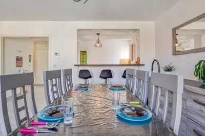 a dining room with a glass table and chairs at Appartement Berthelotine - Welkeys in Cannes
