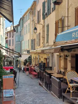 a group of people walking down a narrow street at Place du Suquet - In the hart of old Cannes - 2 Min Walking distance from Palais de Festivals and Beaches in Cannes