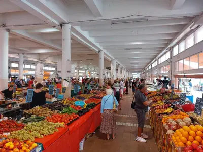 a group of people in a market with fruits and vegetables at Place du Suquet - In the hart of old Cannes - 2 Min Walking distance from Palais de Festivals and Beaches in Cannes
