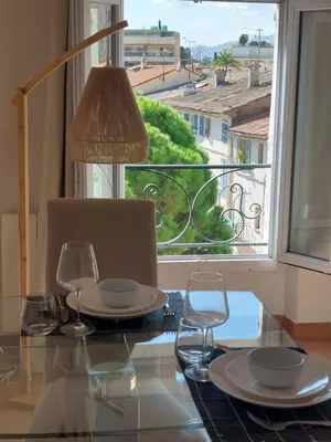 a dining table with glasses and a view of a window at Place du Suquet - In the hart of old Cannes - 2 Min Walking distance from Palais de Festivals and Beaches in Cannes