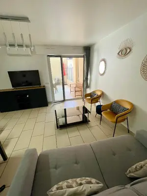 a living room with a couch and a tv at Jolie 3 pièces avec terrasse au vieux port, à 2 pas des plages et du palais. in Cannes
