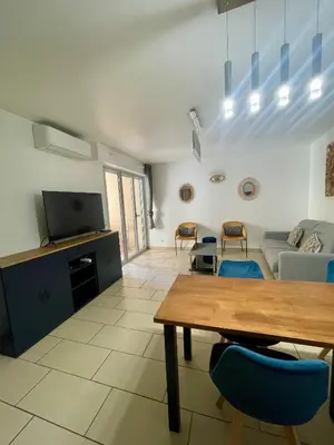a living room with a table and a couch at Jolie 3 pièces avec terrasse au vieux port, à 2 pas des plages et du palais. in Cannes
