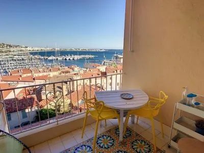 a balcony with a table and chairs and a view of a harbor at 2 bedroom, 2 bathrooms Suquet with sea view 314 in Cannes