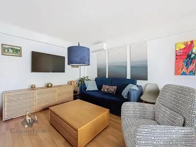 a living room with a couch and a tv at Océan front apartment in Cannes