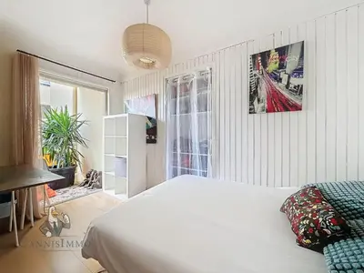 a bedroom with a white bed and a window at Océan front apartment in Cannes