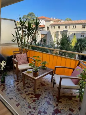 a patio with chairs and tables on a balcony at Océan front apartment in Cannes
